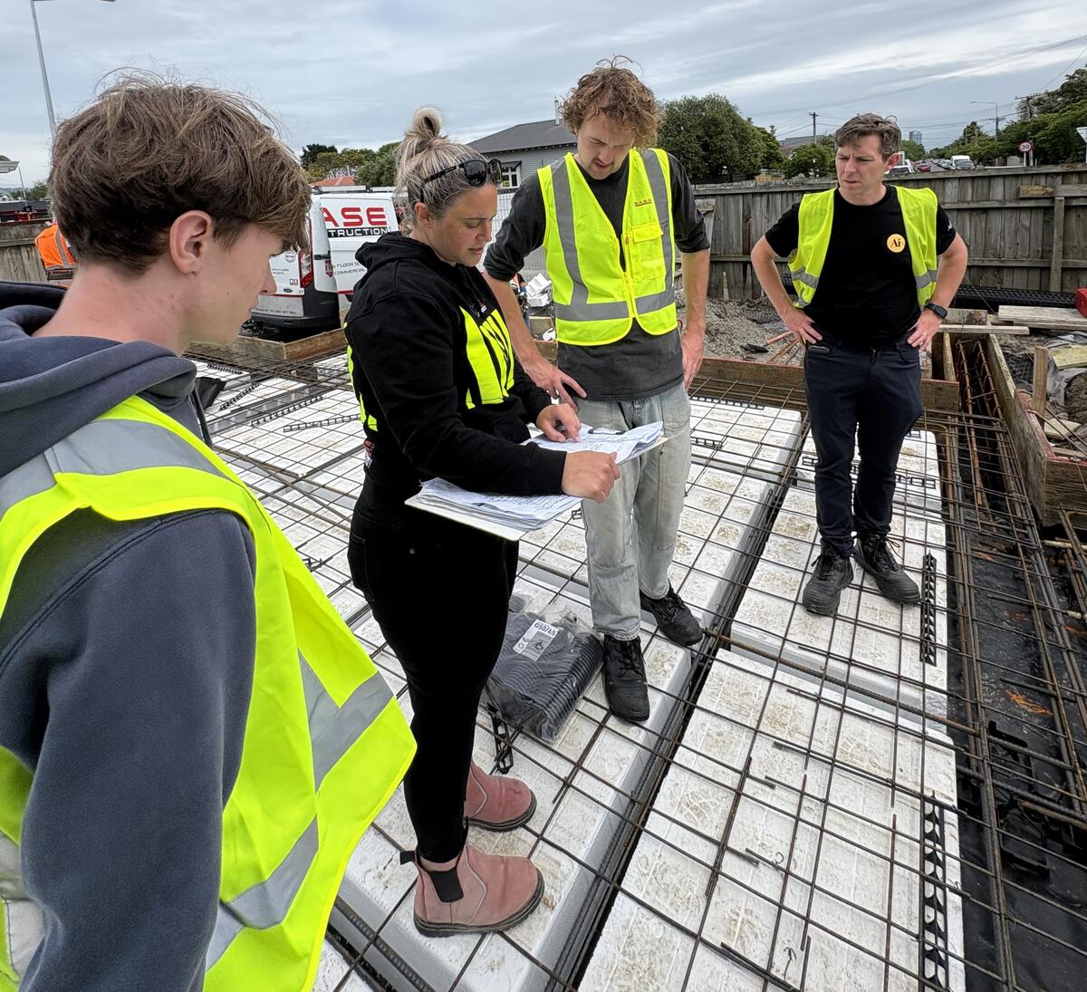 Construction team reviewing plans on a foundation site in New Zealand